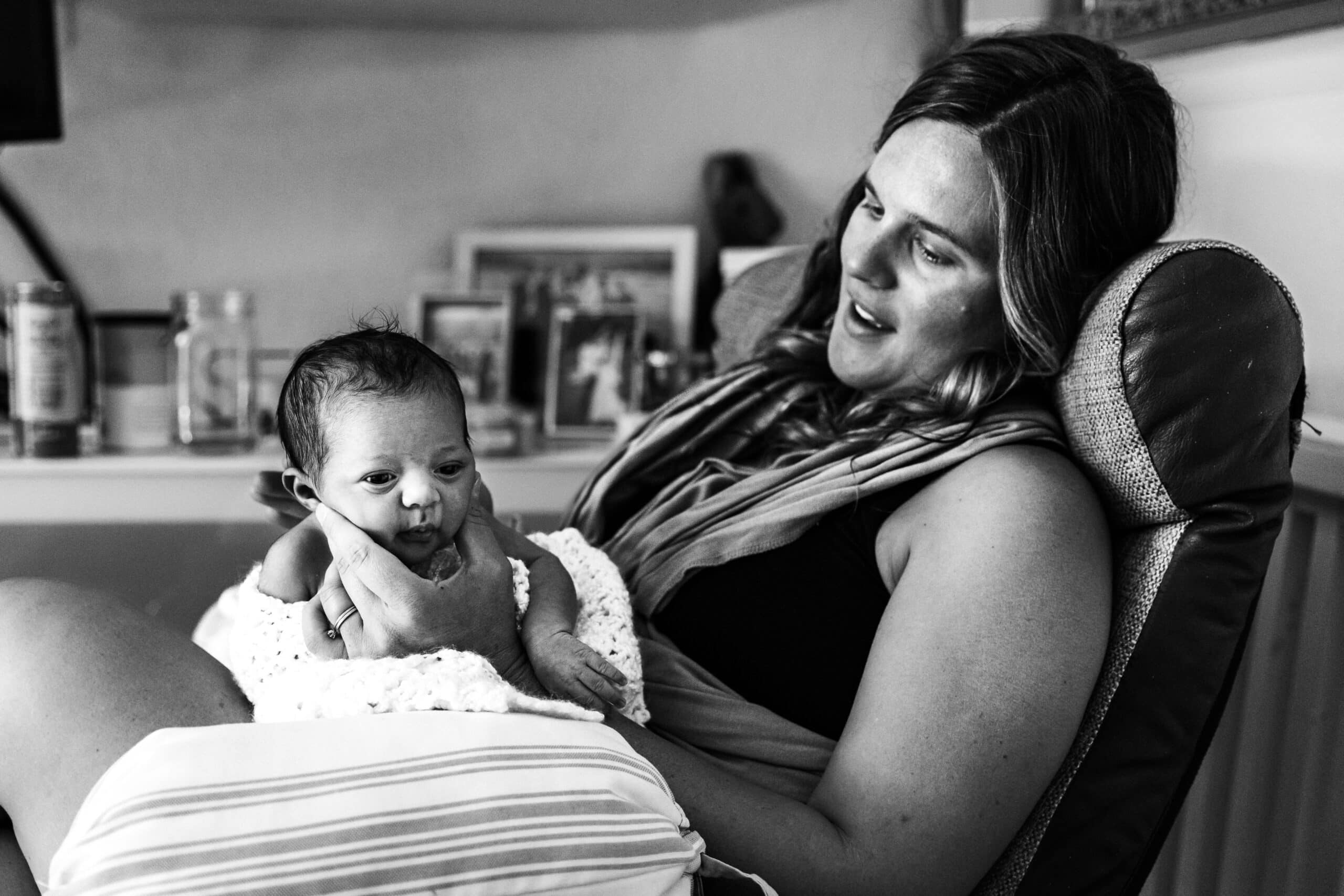 Black-and-white newborn portrait of mother and baby at home