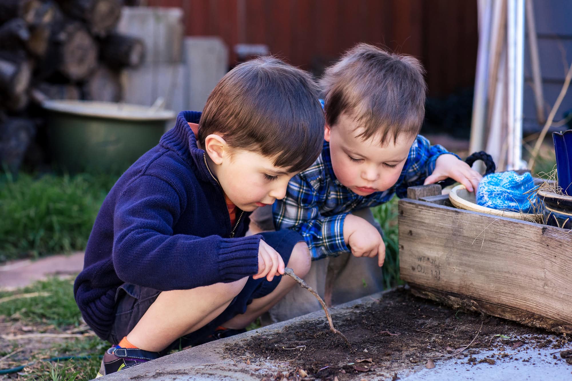 Two brothers playing in the dirt during a documentary family photography session.