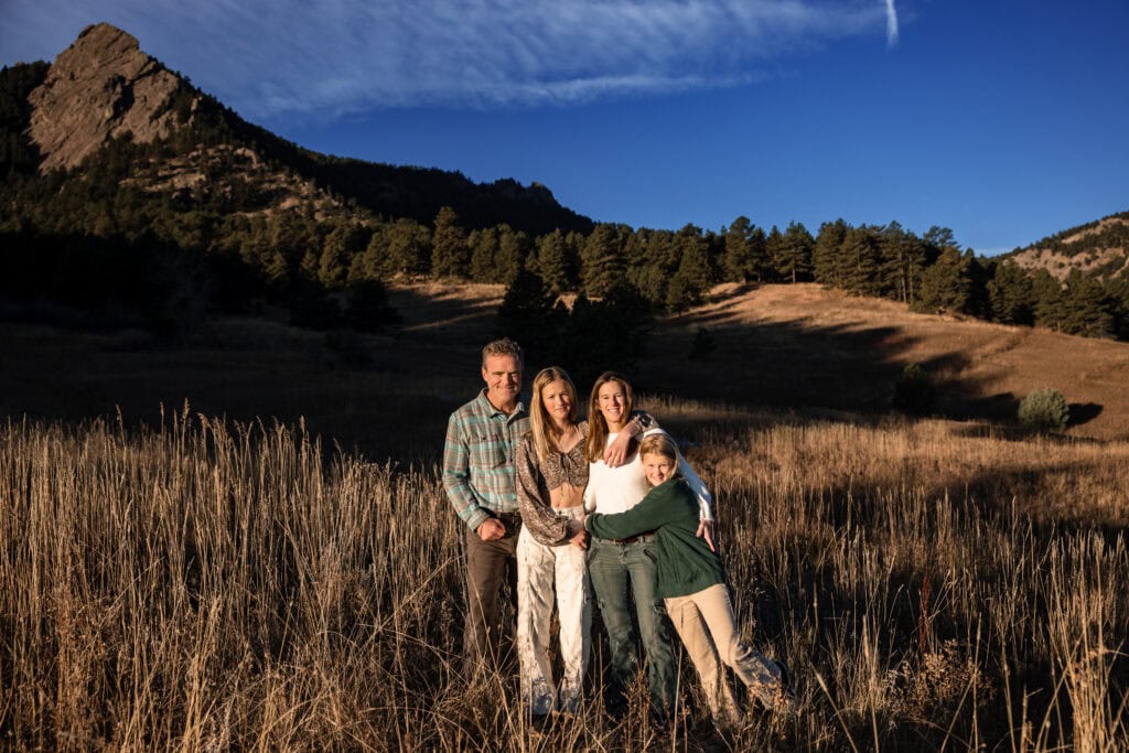 A portrait of a family of four at the flatirons in Boulder Colorado during their lifestyle family photography session.