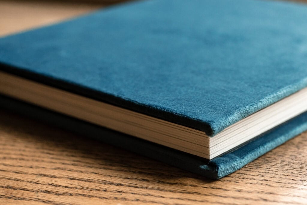Teal cloth book on wooden table for Photography Services