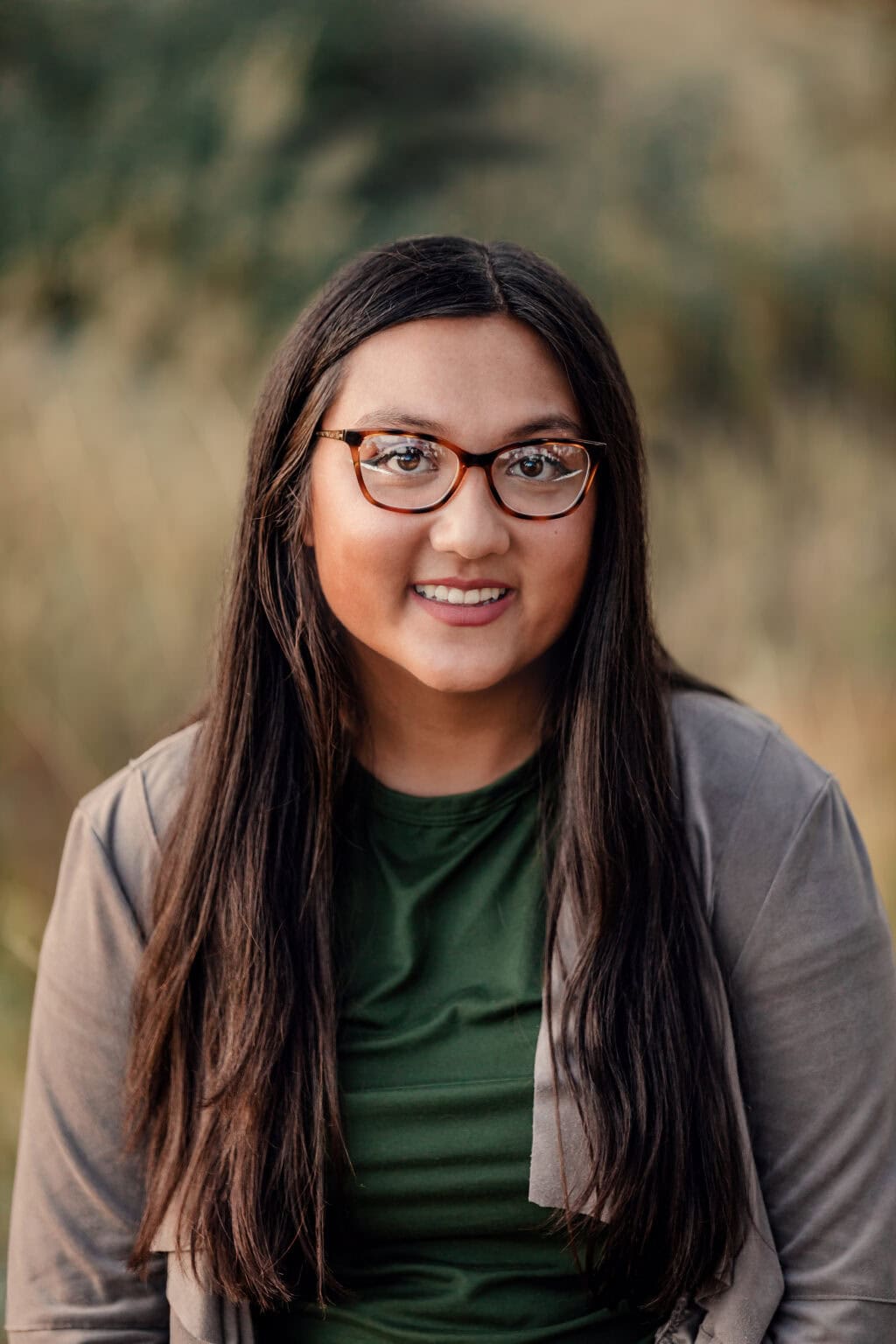 Colorado senior pictures of a smiling young woman with glasses at golden hour