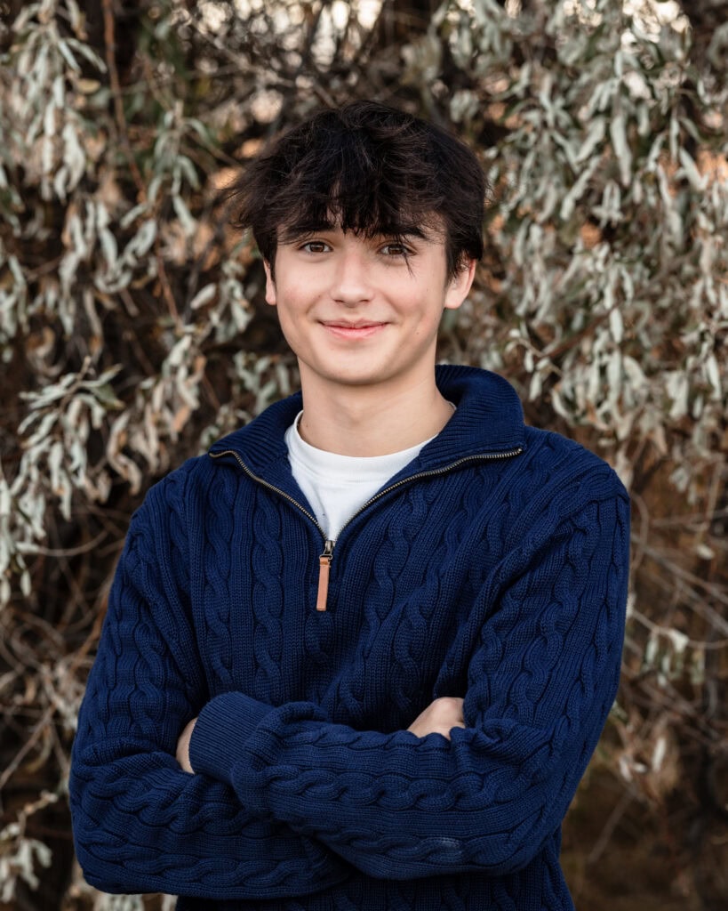 a high school senior during a relaxed outdoor portrait session in the Boulder, Colorado foothills with mountain views.
