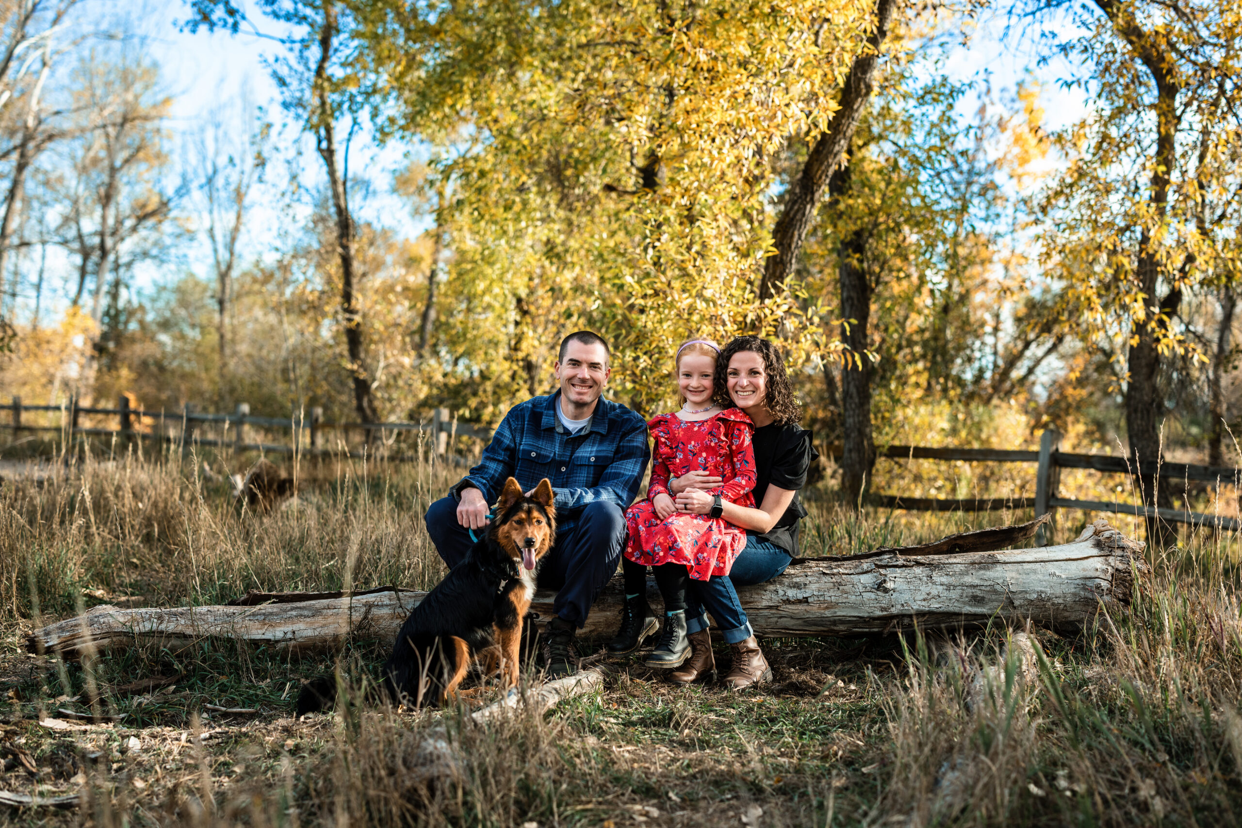 A portrait of a family in a forest of cottonwood trees.