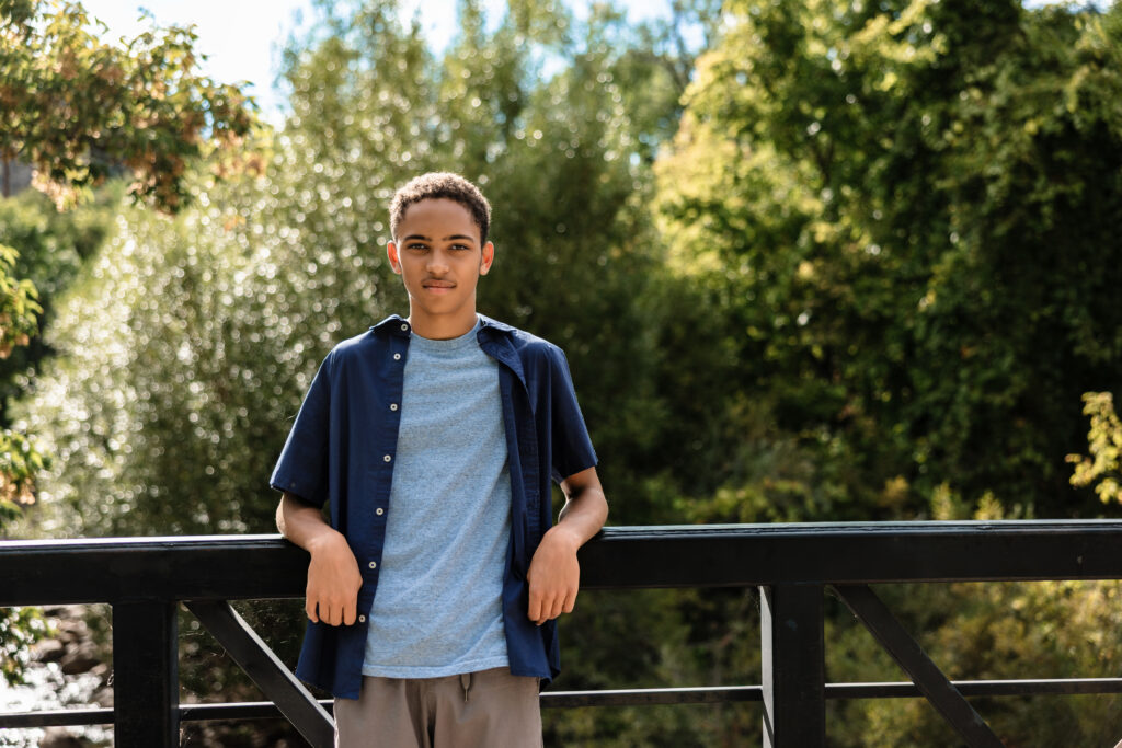 High school senior standing on a bridge at Eben G. Fine Park in Boulder during a natural portrait session