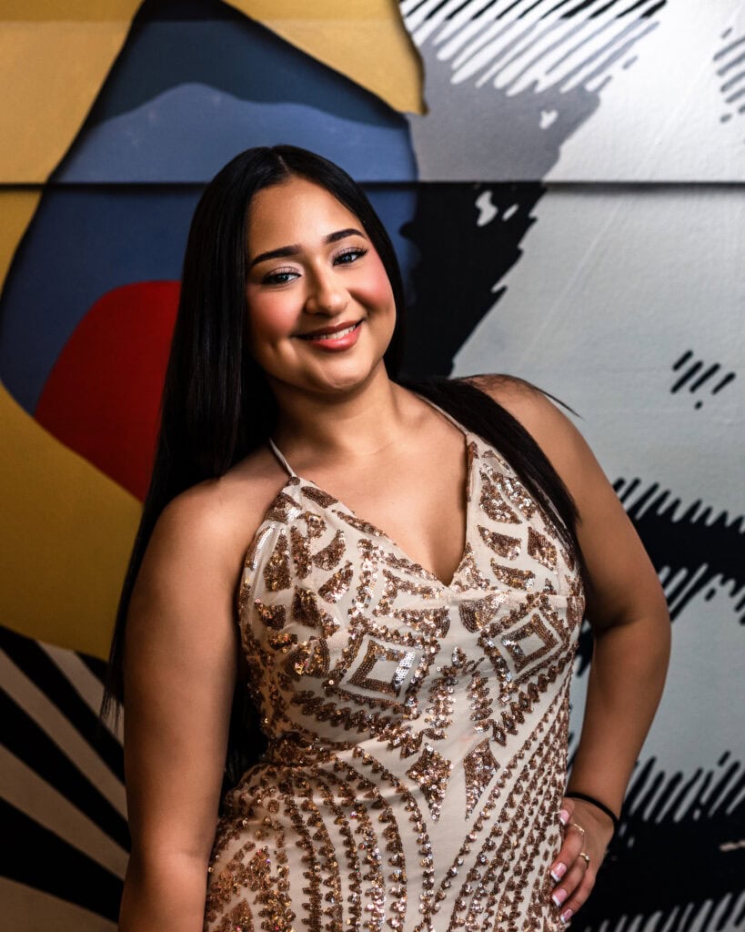 Graduate Mini Sessions portrait of smiling senior in embellished dress by colorful Denver mural